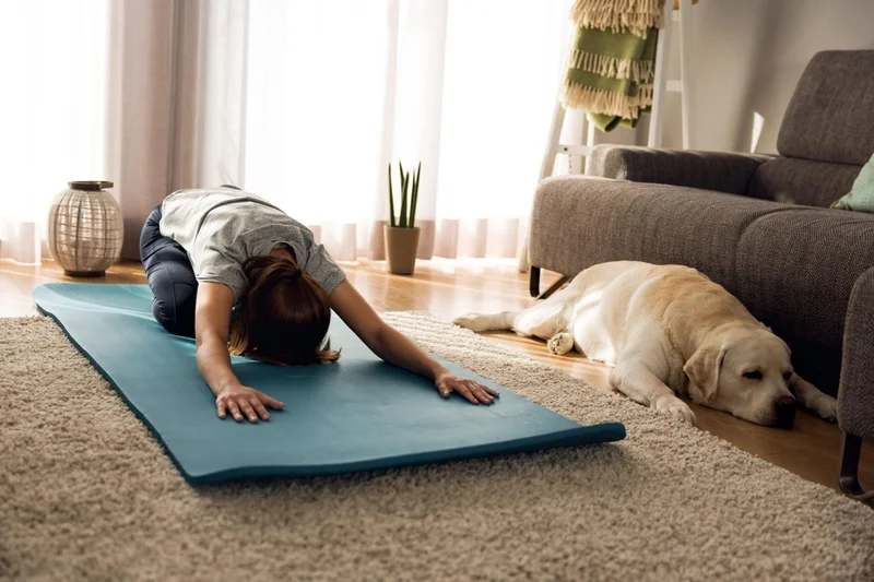 East Coast Telepsychiatry - 10 Great Ways to Improve Your Mental Health. Photo of a woman doing exercise at home with her dog.
